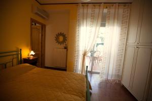 een slaapkamer met een bed en een groot raam bij Phalanthos B&B in Leporano