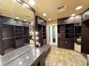 un grand dressing avec des armoires en bois et un grand miroir dans l'établissement فيلا داخل كمبواند ويستاون بيفرلي هيلز الشيخ زايد رقم هاتف صفر صفر اتنين صفر واحد واحد صفر اتنين اربعه ثلاثه صفر 222, à Sheikh Zayed 24 autres photos