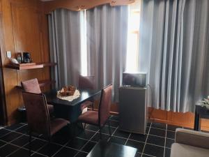 a room with a table and chairs and a television at Hotel Rio Nazas in Torreón
