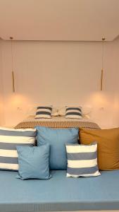 a bedroom with a bed with blue and white pillows at Rida Village Ksamil Island in Ksamil