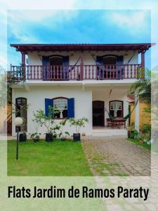 a white house with a balcony and the words flats jaoni de ramos party at Flats Jardim de Ramos em Paraty, RJ in Paraty
