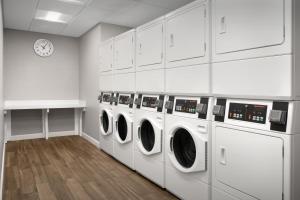 a laundry room with washing machines and a clock at Residence Inn by Marriott San Antonio SeaWorld /Westover Hills in San Antonio +74 photos