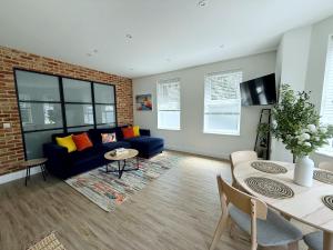 a living room with a blue couch and a brick wall at Abstract Escape! Stylish Apartment, Free Parking, 5 Minutes from Beach in Bournemouth