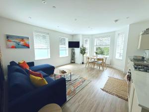 a living room with a blue couch and a table at Abstract Escape! Stylish Apartment, Free Parking, 5 Minutes from Beach in Bournemouth