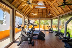 a gym with treadmills and ellipticals in a room with windows at Alamar Vallarta vta in Cruz de Huanacaxtle