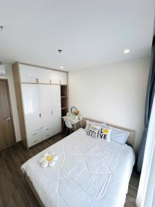 a bedroom with a white bed with flowers on it at An Nhiên Homes 1PN View Đẹp Check-in Tự Do Gần Vincom Mega Mall1316 in Gò Công +4 photos
