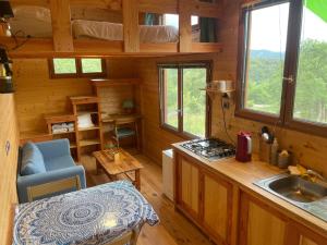 a kitchen and living room of a log cabin at Tiny House en bois in Cubières-sur-Cinoble