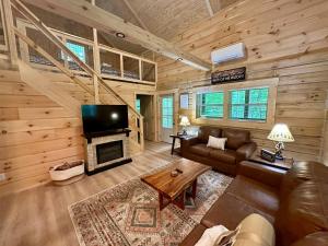 a living room with a couch and a tv in a cabin at Boulder Ridge Cabin in Eckerty