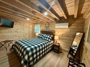 a bedroom with a bed in a wooden cabin at Boulder Ridge Cabin in Eckerty