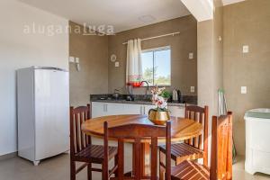 a kitchen with a table and chairs and a refrigerator at Ocean Breeze - Frente para o Mar in Jaguaruna