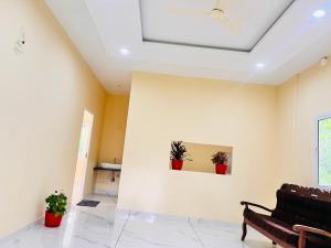 a living room with a couch and two potted plants at prauvilla homestay in Padinjarathara +17 photos