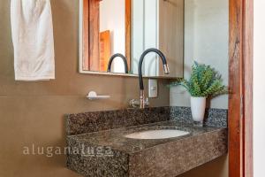 a bathroom with a sink and a mirror at Ocean Breeze - Frente para o Mar in Jaguaruna +13 photos