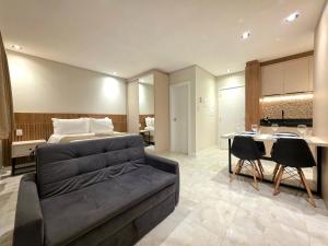 a living room with a bed and a dining room at Studio Novo no Centro para 4 pessoas in Foz do Iguaçu