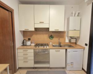 a kitchen with white cabinets and a stove top oven at Central Apartment Caniggia 1 with Terrace in Como in Como