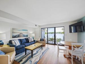a living room with a blue couch and a table at 103 Edgewater Inn in Charlevoix
