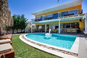 a swimming pool in front of a house at ALDEBARAN HOMES in Limenaria