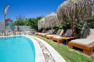 a swimming pool with chaise lounges and lounge chairs next to a resort at ALDEBARAN HOMES in Limenaria