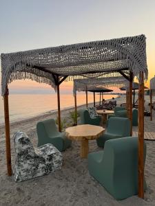 a group of tables and chairs on the beach at G&S Dionisiou Apartment in Paralia Dionysiou