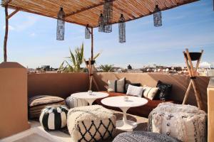 a patio with two tables and chairs on a roof at Dar Maya Original Suite & Spa in Fez