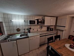 a small kitchen with white appliances and a table at Ferienwohnung Helma Richter in Rathmannsdorf