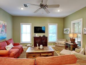 a living room with couches and a flat screen tv at Sand Piper in Seacrest