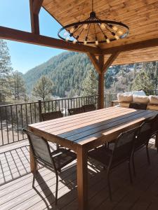 una mesa de madera y sillas en una terraza con vistas en Breathtaking View 12 Min to Downtown, en Durango