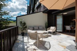 a patio with a couch and a table on a balcony at Durmitorka Luxury Villas in Žabljak