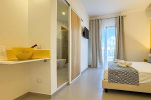 a bedroom with a bed and a bathroom with a tub at Tevergad Premium Rooms in Terrasini