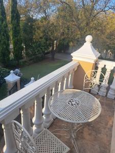 a white railing with a table and chairs on a balcony at 28 on Oribi in Welkom +2 photos