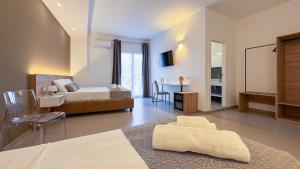a bedroom with a bed and a table with a chair at Tevergad Premium Rooms in Terrasini