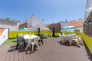 a patio with tables and umbrellas on a roof at Suntrap Hostel in Lagos