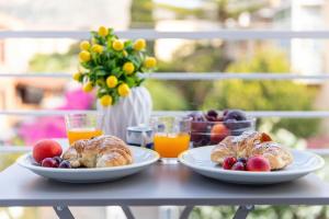 a table with two plates of pastries and orange juice at Tevergad Suites & Rooms in Terrasini