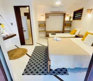 a room with two beds and a living room at Villa Caribou in Icaraí