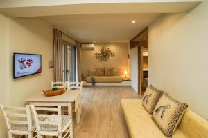 uma sala de estar com uma mesa e cadeiras e um quarto em Forest Resort Suites Skiathos em Troulos