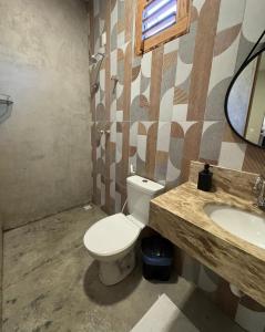 un baño con inodoro y lavabo en Casita Beach House, en Itarema