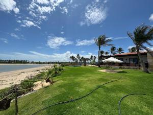 a house with a lawn next to the beach at Casita Beach House in Itarema
