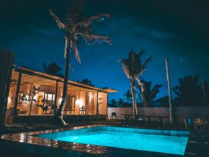 a villa with a swimming pool at night at Casita Beach House in Itarema