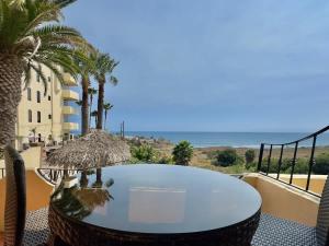 a table on a balcony with a view of the ocean at Puerto Nuevo Villa Olas 2BR 2BA with pool in Raulis