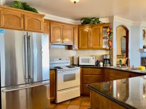 RaulisにあるPuerto Nuevo Villa Fiesta 2BR 2BA with poolのキッチン(木製キャビネット、ステンレス製の冷蔵庫付) +17枚の写真