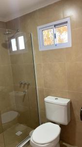 a bathroom with a toilet and a shower with a window at Establecimiento Don Elder in Sunchales +19 photos
