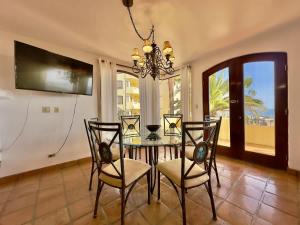 a dining room with a table and chairs and a chandelier at Puerto Nuevo Surf Villa Margarita 2BR with pool in Raulis +16 photos