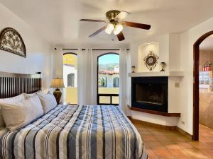 a bedroom with a bed with a ceiling fan and a fireplace at Puerto Nuevo Surf Villa Flores 2BR with pool in Raulis