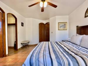 a bedroom with a bed and a ceiling fan at Puerto Nuevo Surf Villa Flores 2BR with pool in Raulis