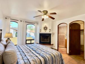 a bedroom with a ceiling fan and a fireplace at Puerto Nuevo Surf Villa Flores 2BR with pool in Raulis