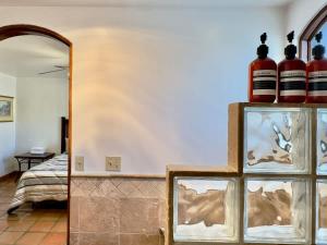 a room with a mirror and some bottles on a shelf at Puerto Nuevo Surf Villa Flores 2BR with pool in Raulis