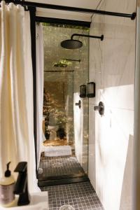 a shower with a glass door in a bathroom at Modern Mirror Home w/ Hot-tub | “Glass House” #2 in High Falls