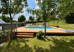 ein Swimmingpool mit Holzdeck neben einem Hof in der Unterkunft Ferienwohnungen Brenner einchecken und wohlfühlen in Langenbernsdorf