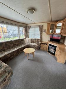 a living room with a couch and a table and a tv at Helove Domki Karoliny in Hel