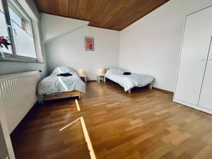 two beds in a room with wooden floors at sleepWELL-Horstmar II Zentral & Komfort in Horstmar