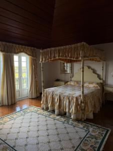 1 dormitorio con cama con dosel y alfombra en Herdade das Bernardas, en Vila Verde de Ficalho